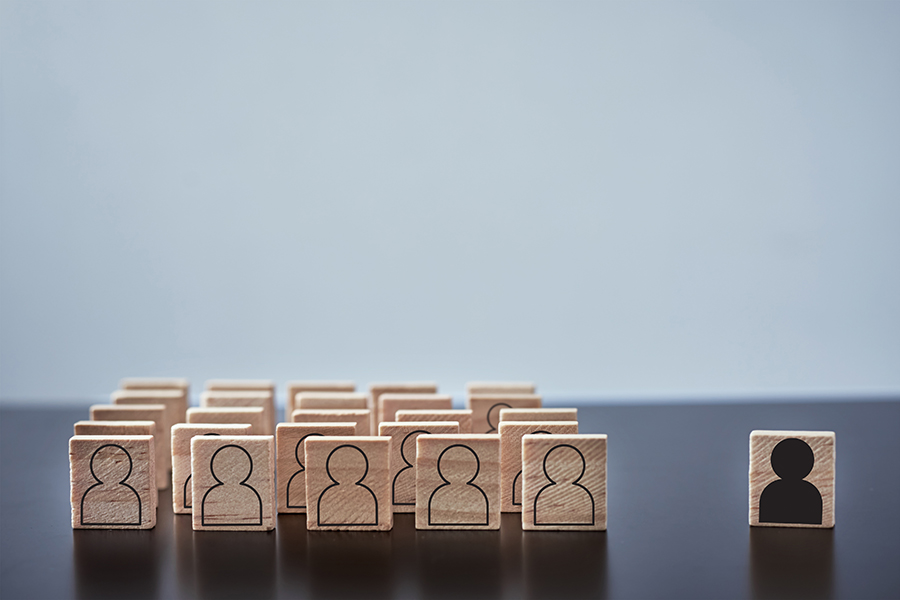 Concept of racism and misunderstanding between people, prejudice and discrimination. Wooden block with white people figures and one with black man