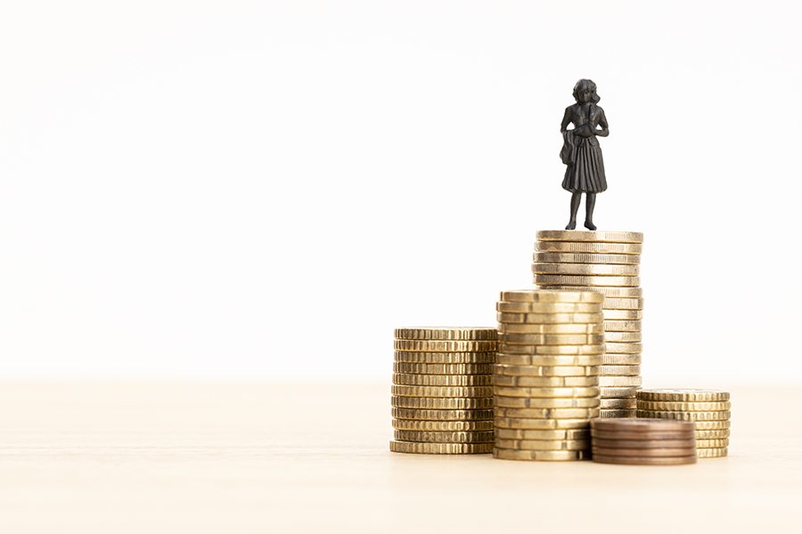 Wealth, making money, wage growth concept. Woman figurine standing on a pile of coins. Copy space